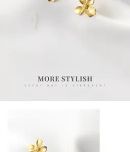 Detail shot of the matte gold four-petal flower silver stud earrings on soft white satin.
