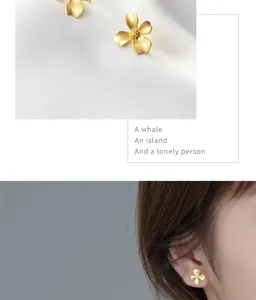 Close-up detail of s925 sterling silver frosted gold four-petal gardenia flower earrings.