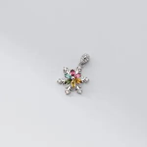 Gros plan détaillé du pendentif flocon de neige exquis avec des pierres précieuses multicolores.