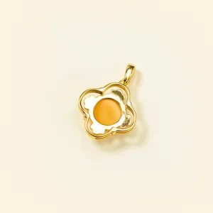 Close-up detail shot of the golden four-petal flower pendant featuring a warm amber center stone.