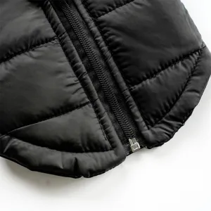 Close-up detail of black quilted pet winter vest zipper, warm puffer jacket for dogs cats.
