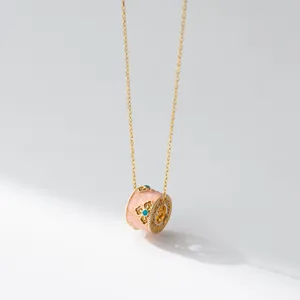 Exquisite detail close-up of the vintage golden barrel pendant necklace with pink enamel floral design.