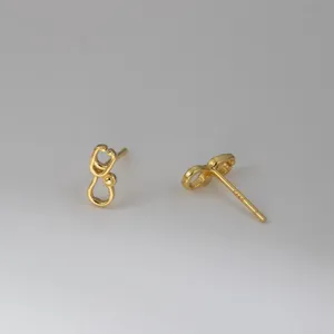Close-up view of minimalist stethoscope stud earrings in sterling silver, delicate medical jewelry.
