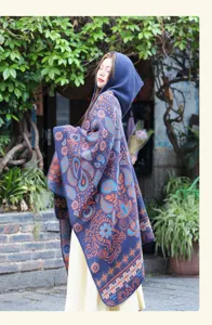 Detail shot of the ethnic style knit hooded cape, showcasing the intricate paisley and floral patterns.