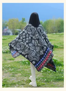 Ethnic style black knitted hooded cloak with paisley flower pattern, outdoor detail view.