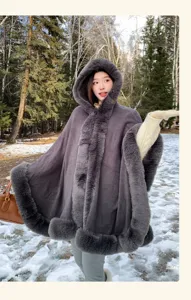 Winter warm faux fur hooded cape detail, dark grey winter cloak outerwear in snowy forest.