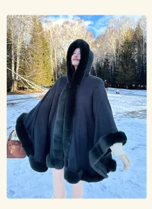 Detailed winter hooded fur trim cape cloak showcase worn by model in snowy forest outdoor.