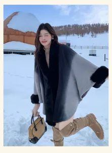Detailed view of the gradient faux fur trimmed cape coat in a snowy outdoor scene, elegant winter.