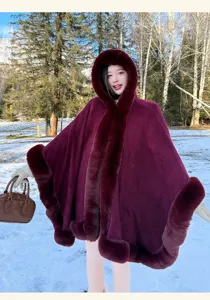 Burgundy faux fur hooded cape detail shot, winter outdoor snowy scene elegance outerwear.