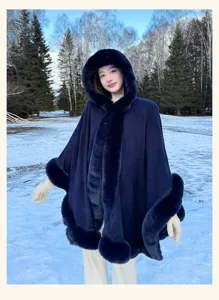 Stylish dark blue faux fur hooded winter cape detail, elegant outdoor snow scene wear.