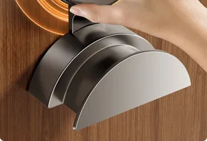 Close-up detail of dark metal punch-free door hook showing push mechanism on wooden door surface.