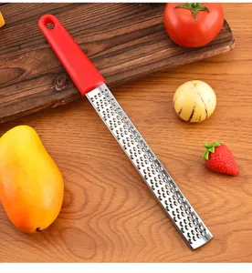 Dettaglio della grattugia da formaggio in acciaio inox con lame affilate e manico ergonomico.