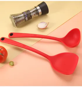 Detail view of red silicone kitchen utensils, non-stick spatula and soup ladle set.