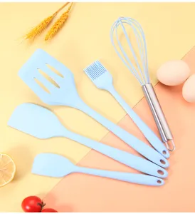 Vista dettagliata del set di utensili da cucina in silicone azzurro chiaro con frusta.