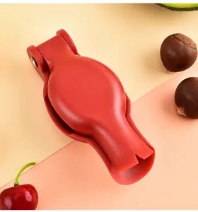 Red plastic chestnut opener tool detail shot, durable nutcracker for easy shell cracking.