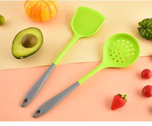 Spatola da cucina in silicone e schiumarola dettaglio, utensili verdi e grigi.