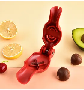 Red plastic chestnut opener tool detail, featuring stainless steel cross blade for nuts.