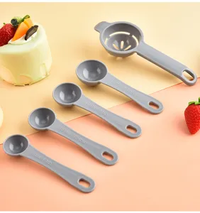 Plastic measuring spoons and egg separator set, baking tools with clear scale marks.