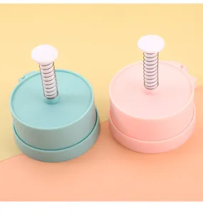 Detail view of plastic burger press mold, spring loaded meat patty maker tool kitchen accessory.