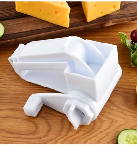 Dettaglio grattugia per formaggio rotativa manuale, attrezzo cucina in plastica bianca verdure.