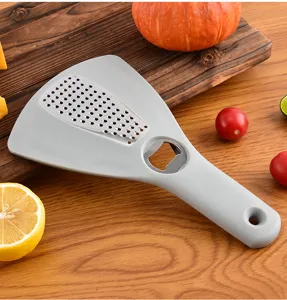 Vue détaillée de la râpe de cuisine multifonction et décapsuleur, outil de cuisson pratique.
