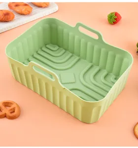 Silicone air fryer basket detail, green rectangular baking pot with handles and ribbed base.
