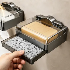 Wall-mounted soap dish with drainage tray and clear cover for bathroom storage.