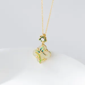 Primo piano dettagliato del ciondolo elegante in giada bianca con fiore e catena d'oro.