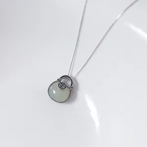 Detailed close-up of S925 silver Hetian jade fortune bag pendant necklace, minimalist design.
