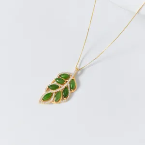 Close-up detail view of the exquisite jade leaf pendant featuring inlaid sparkling stones.