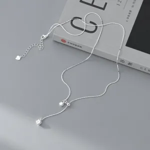 Detail shot of a minimalist S925 silver Y-necklace featuring a delicate texture cube pendant.