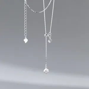 Detail view of the modern minimalist S925 silver Y-shaped necklace with textured cube and heart.