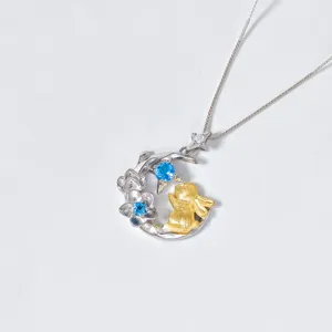 Gros plan détaillé du pendentif collier fleur et lapin en argent S925 topaze bleue.