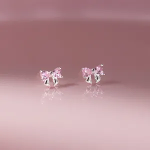 Dettagli in primo piano degli orecchini a perno con fiocco in strass rosa, dolce.