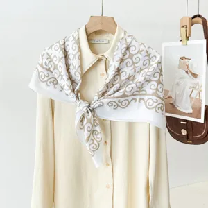 Detailed view of luxury vintage scroll pattern silk scarf styled on shirt, elegant accessory.