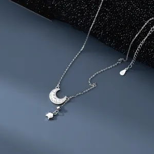 Detaillierte Nahaufnahme einer silbernen Stern- und Mondsichel-Anhängerhalskette mit glitzernden Steinen.