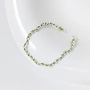 Detailaufnahme des minimalistischen S925 Silberperlen und grünen Kordelarmbands, elegant.