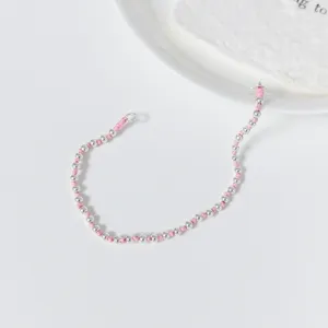 Nahaufnahme Detail von Silberperlen und rosa Kordel Armband, minimalistischer Alltagsschmuck.