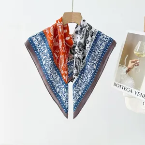 Close-up detail shot of multi-color paisley print square silk scarf hanging indoors.