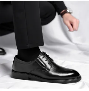 Close-up detail view of black leather derby dress shoes with classic lace-up style.