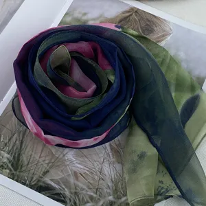 Close-up of lightweight gradient green and blue chiffon scarf, delicate fabric texture.
