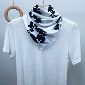 Silk satin square scarf with delicate lace trim, chic black and white pattern design.