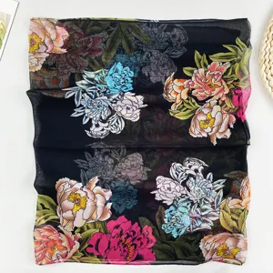 Nahaufnahme eines schwarzen, floral bedruckten Chiffonschals mit filigranem Pfingstrosenmuster.