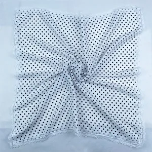 Detailed view of the black and white polka dot silk scarf featuring delicate white lace trim.