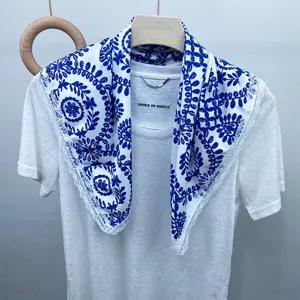 Detailed shot of a blue and white printed silk scarf featuring delicate lace trim decoration.