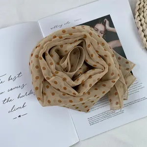 Detail shot of vintage polka dot georgette scarf, lightweight beige summer neck accessory.