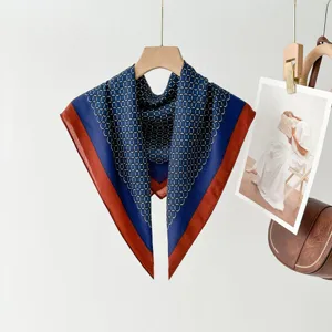 Detailed view of retro blue square scarf with red border and chain pattern, elegant accessory.