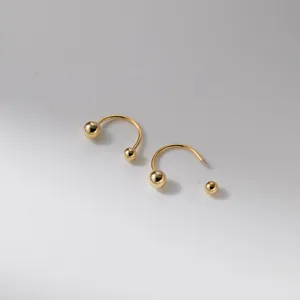 Detailansicht minimalistischer goldener Hufeisen-Piercingringe mit Kugelgewinde für Körperschmuck.