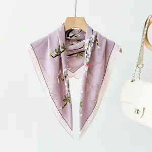 Detailed view of the elegant light purple floral square scarf hanging on a wooden hanger.