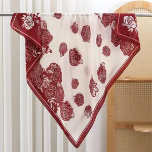 Detail shot of elegant white square scarf with red rose pattern, silky smooth twill fabric.
